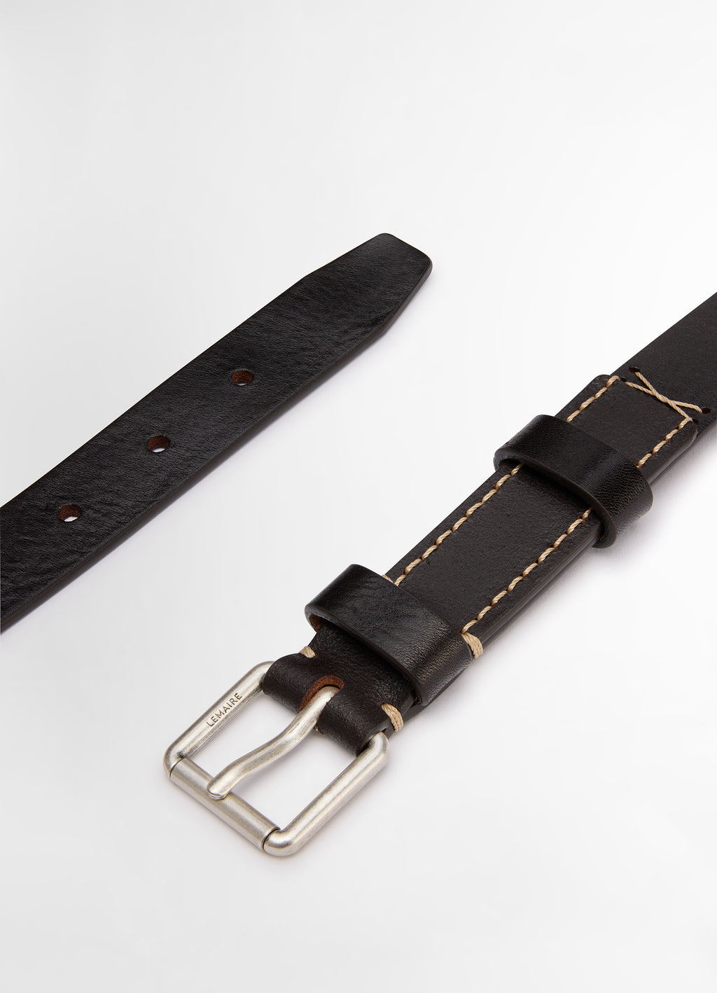 Lemaire reversed belt 25 in smooth vegetable leather, product shot, angled close-up view contrasting stitch detail