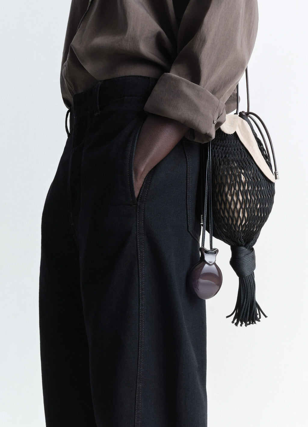 Lemaire castanet necklace in dark brown resin, model shot, side perspective view elegant curved pendant