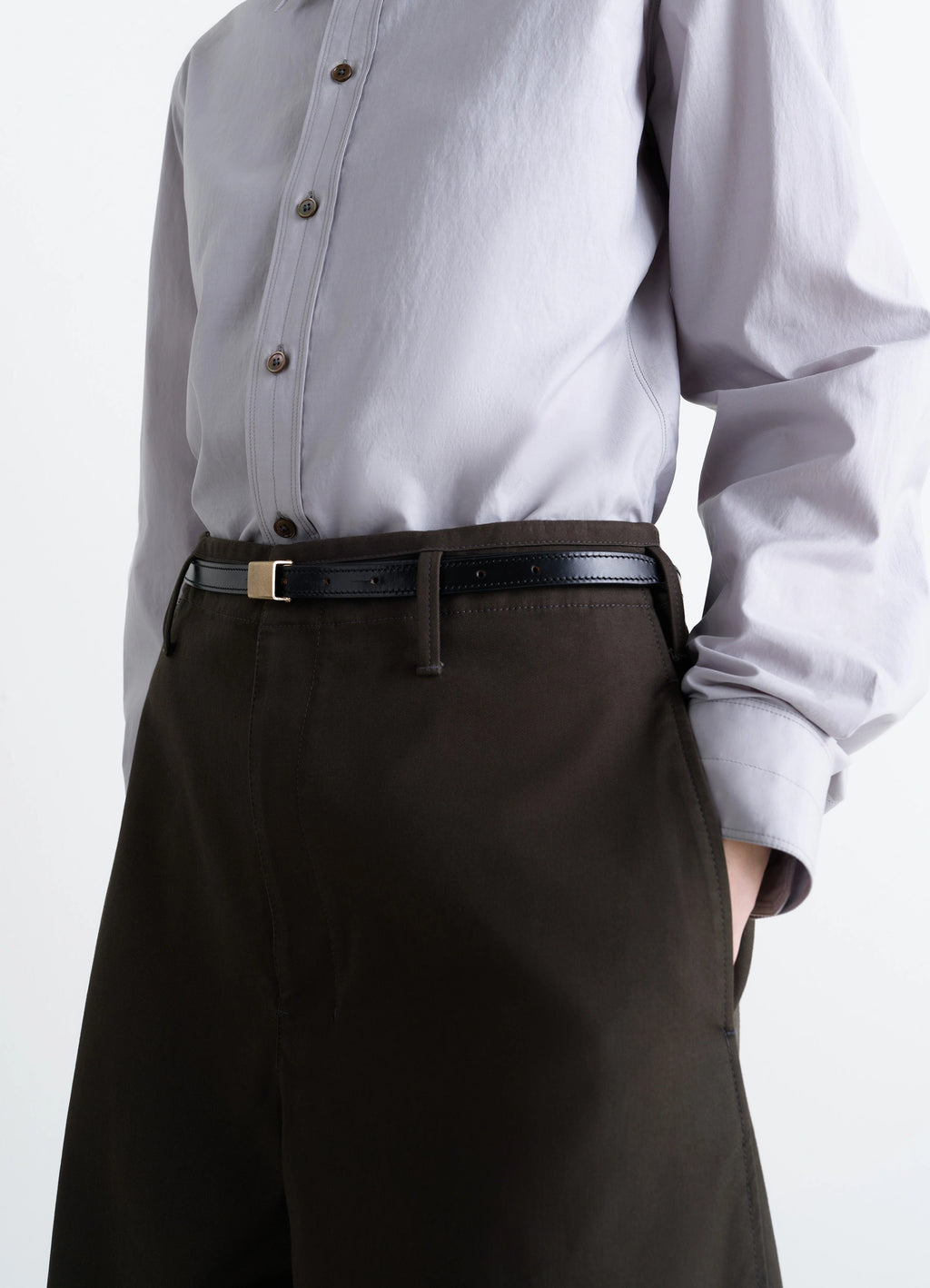 Lemaire clip belt 15mm in vegetable-tanned black leather, model shot, detail waist view worn around waist