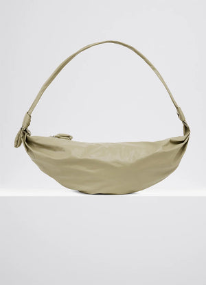 Medium soft croissant bag in lightweight shiny leather, product shot, front view side knot finishings