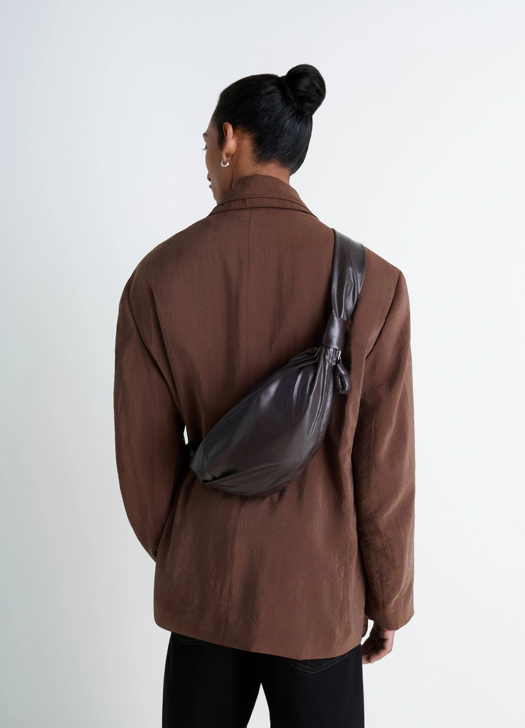 Small soft croissant bag in paper-effect leather, model shot, over the shoulder curved silhouette