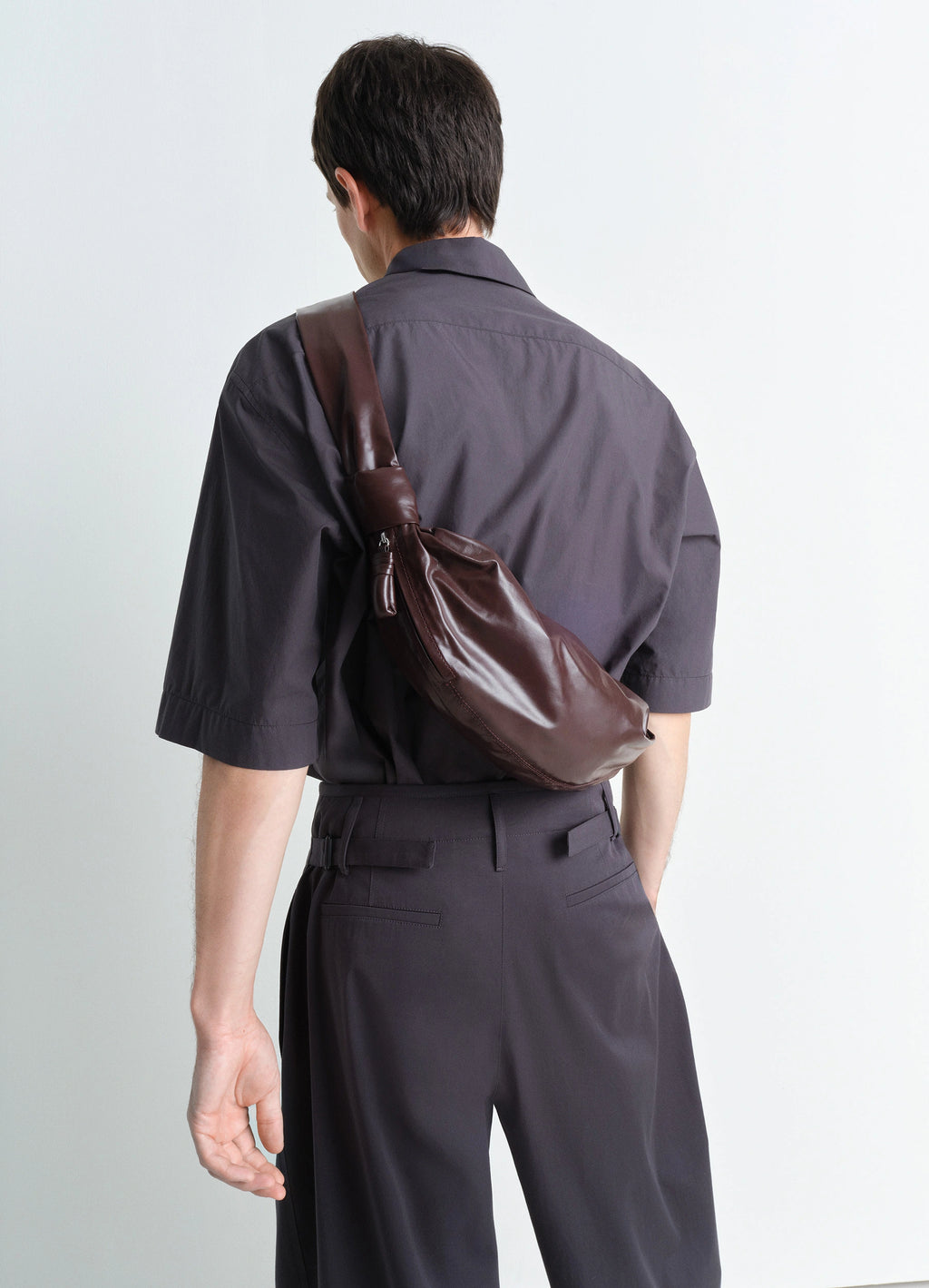 Lemaire small soft croissant in paper-effect leather, model shot, back view knotted strap design