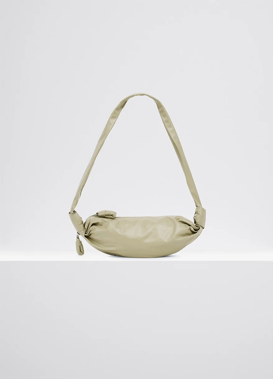 Small soft croissant in lightweight shiny leather, product shot, side view draped with side knots