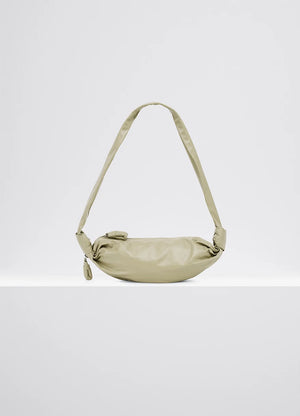 Small soft croissant in lightweight shiny leather, product shot, side view draped with side knots