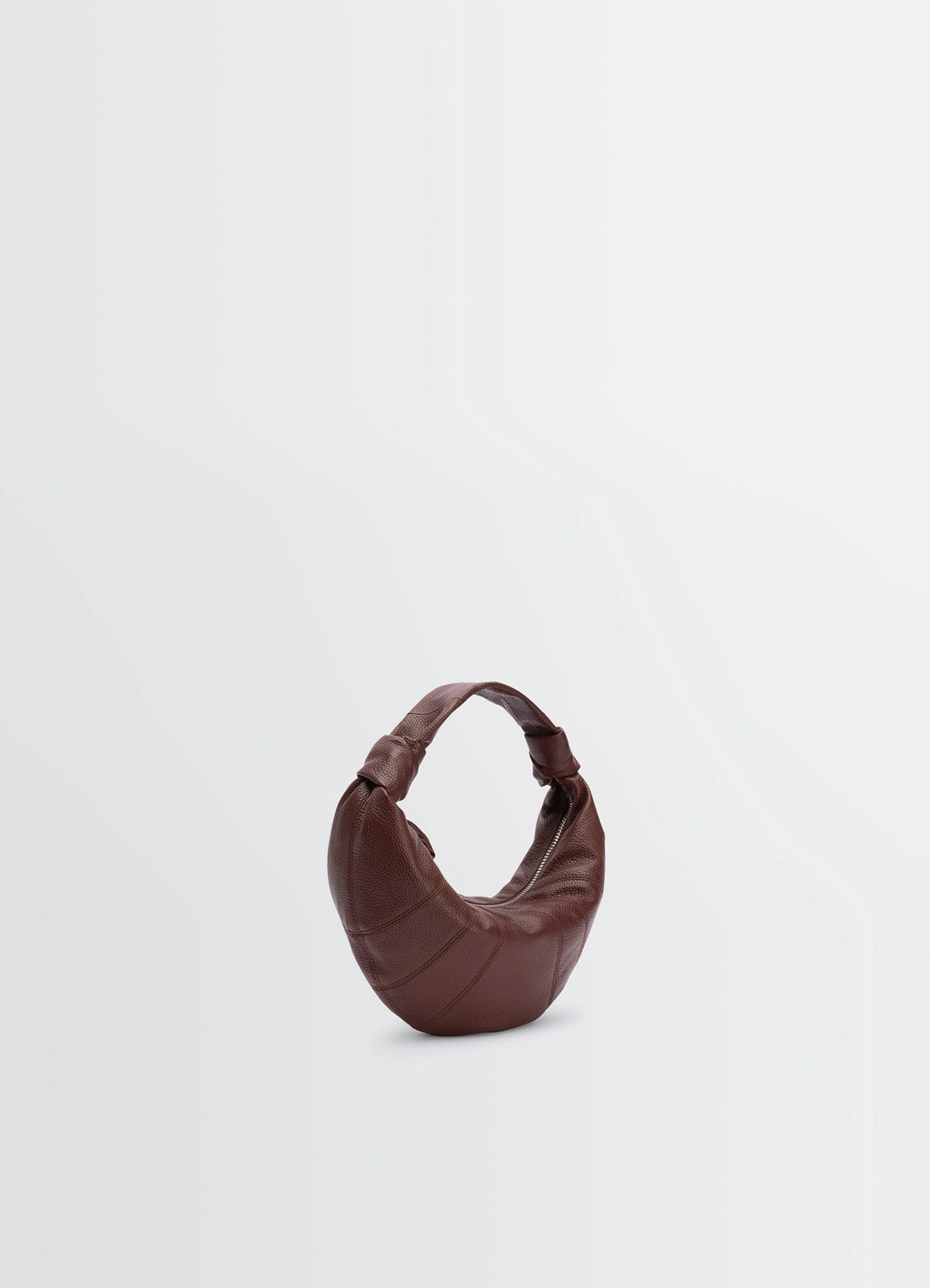 Mini fortune croissant bag in brown grained leather, product shot, three-quarter view arched top handle