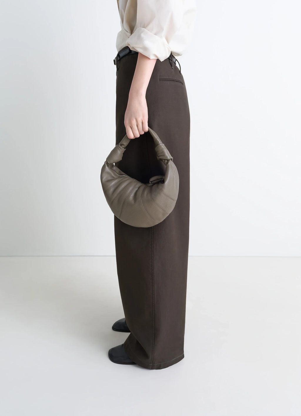 Mini fortune croissant bag in grained leather, model shot, side view half-moon silhouette