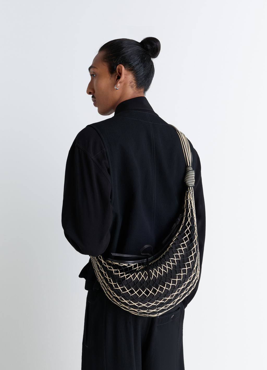 Croissant filt bag in nylon net black, model shot, back view worn crossbody