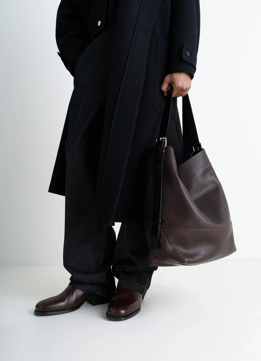 Belted tote bag in lwg gold-certified grained leather, model shot, side view worn by model with dark coat
