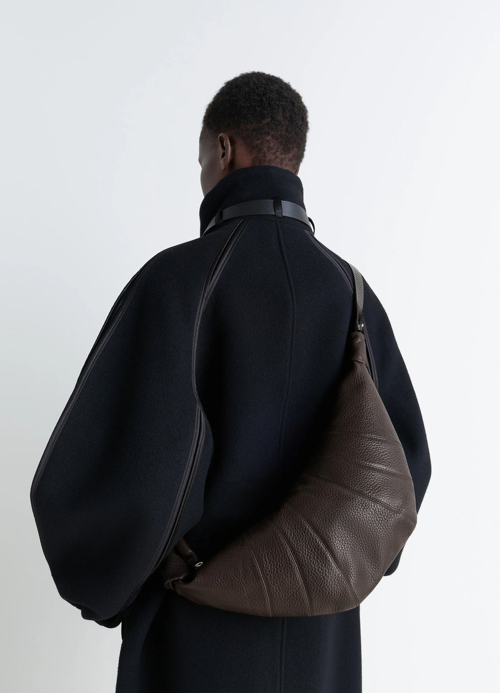 Rail belt medium croissant bag in grained leather in brown, model shot, back view embossed leather with strap