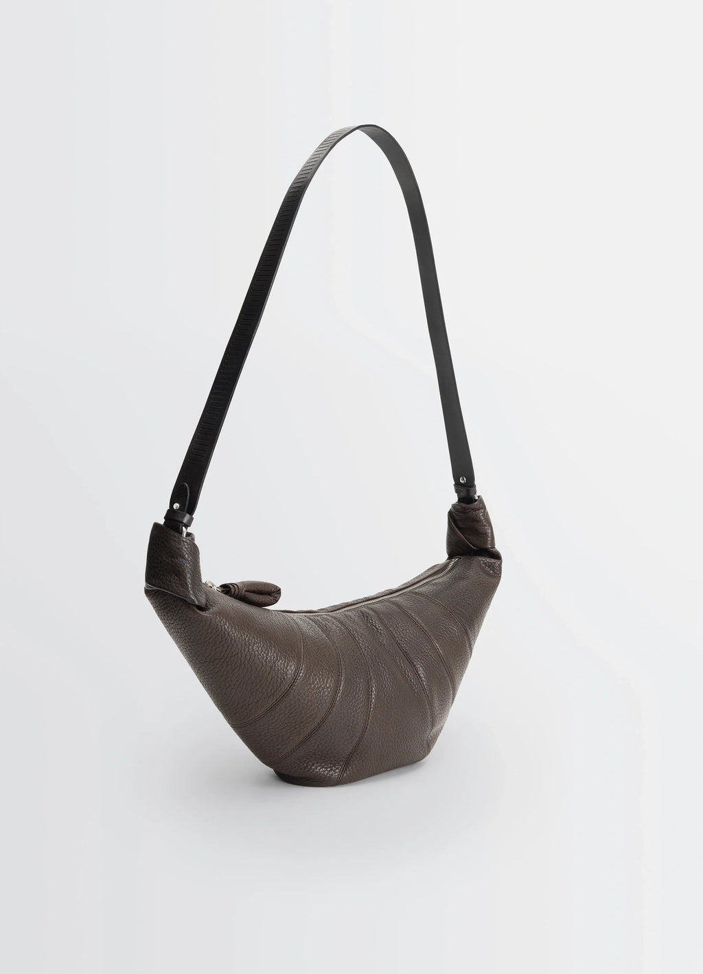 Rail belt medium croissant bag in grained leather in brown, product shot, angled top view textured grained surface