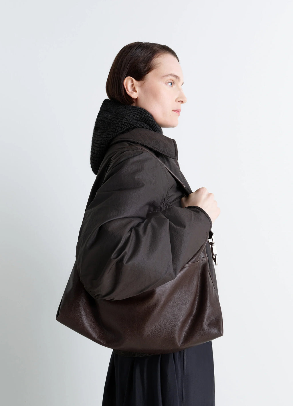 Berlingot hobo bag in glazed paper leather, model shot, over-the-shoulder view minimalist design