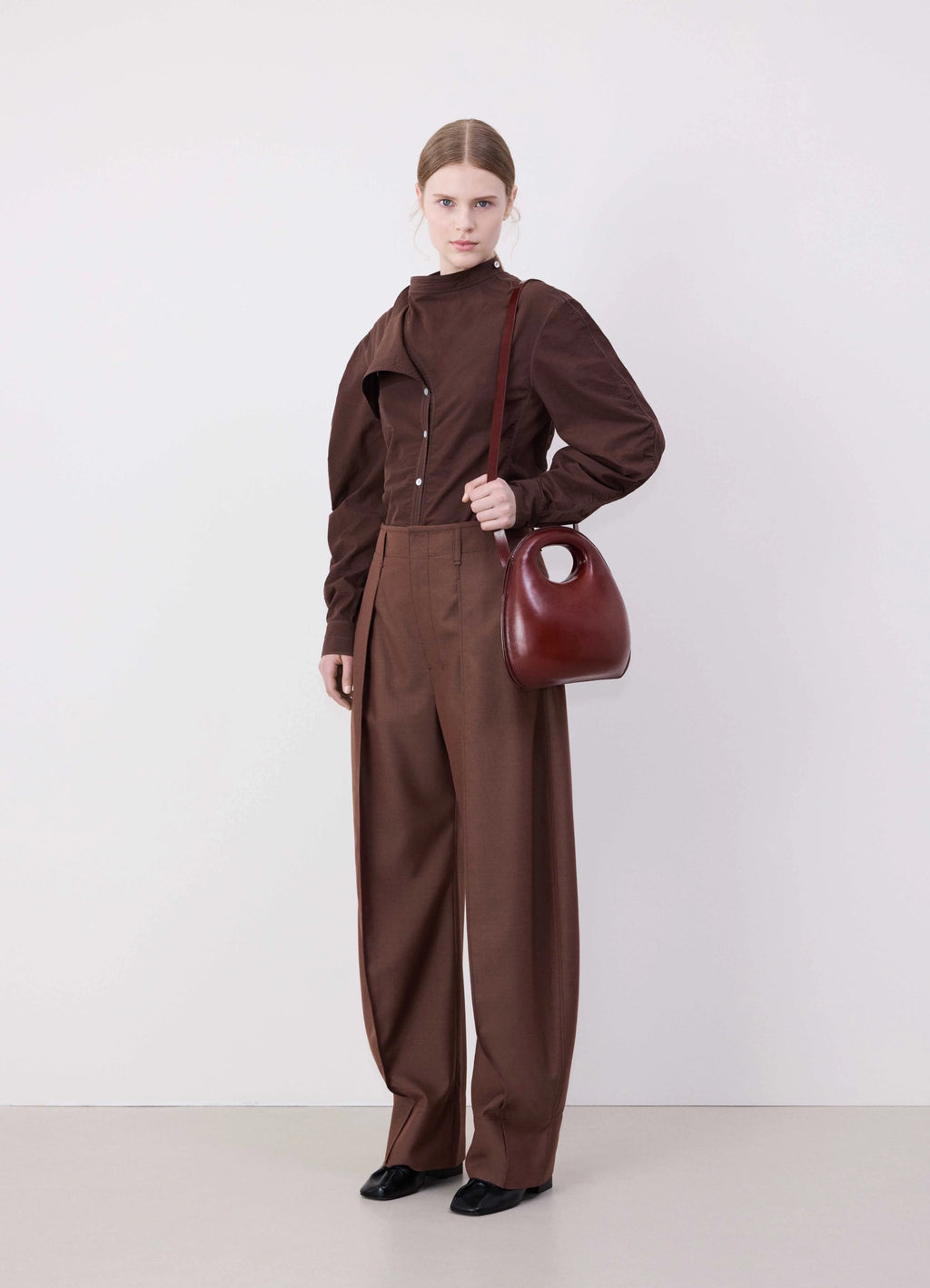 Lemaire egg bag in smooth vegetable-tanned cowhide, model shot, side view worn on shoulder