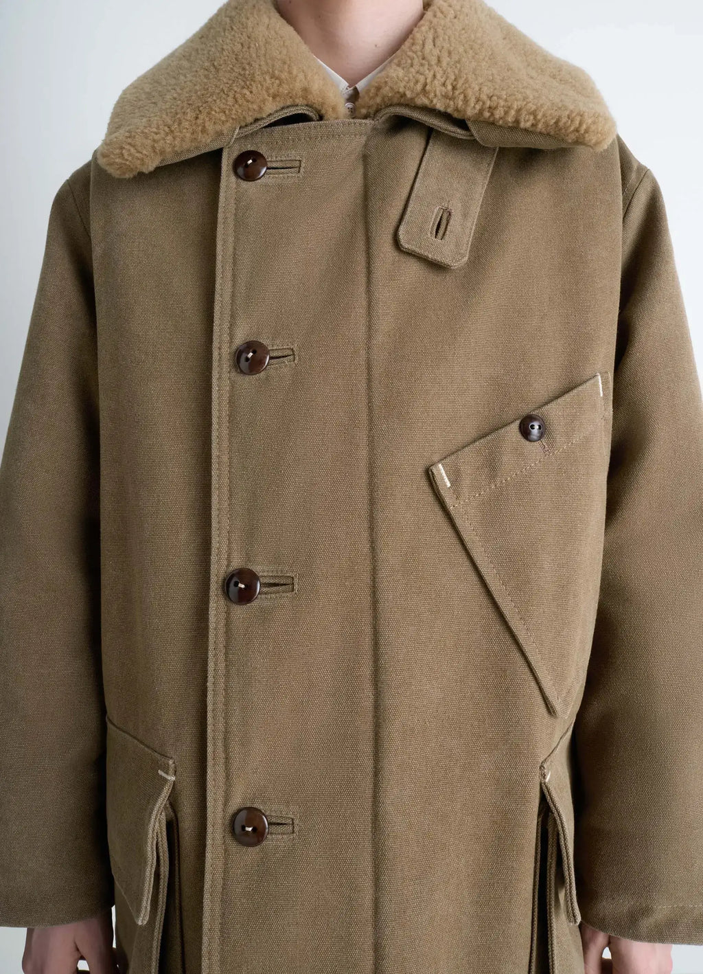 Shearling winter parka in brown cotton canvas, model shot, close-up button detail quilted lining highlight