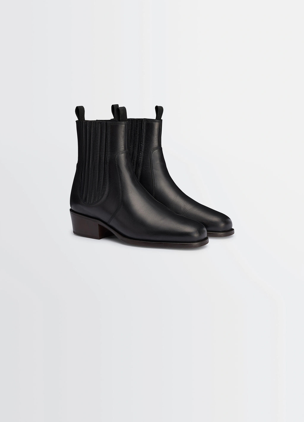 Chelsea boots in black vegetable-tanned leather, product shot, three-quarter view dual pull-tabs