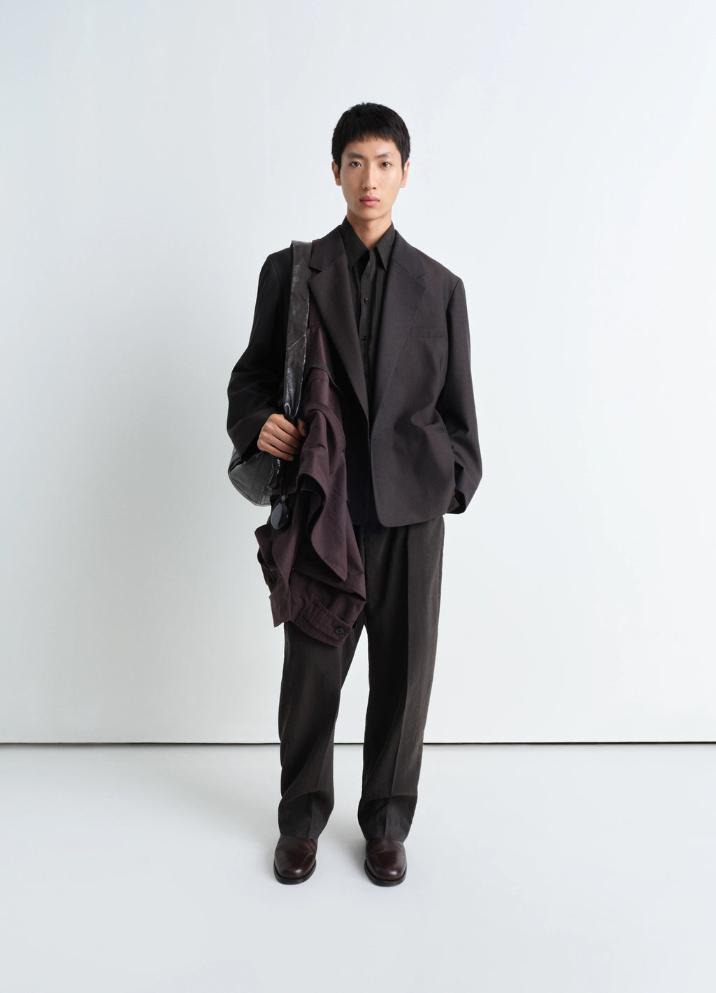 Lemaire soft double breasted jacket in tropical poly-wool mélange twill, model shot, three-quarter view relaxed fit, straight