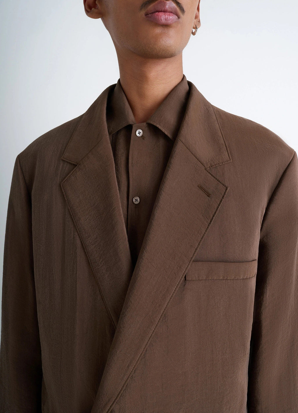 Lemaire soft double-breasted jacket in heather brown dry silk blend, model shot, close-up side view lapel and button detail