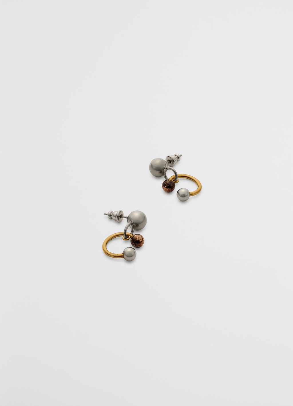 Lemaire rattle earrings in silver, copper, gold brass, product shot, side view asymmetrical metallic loops