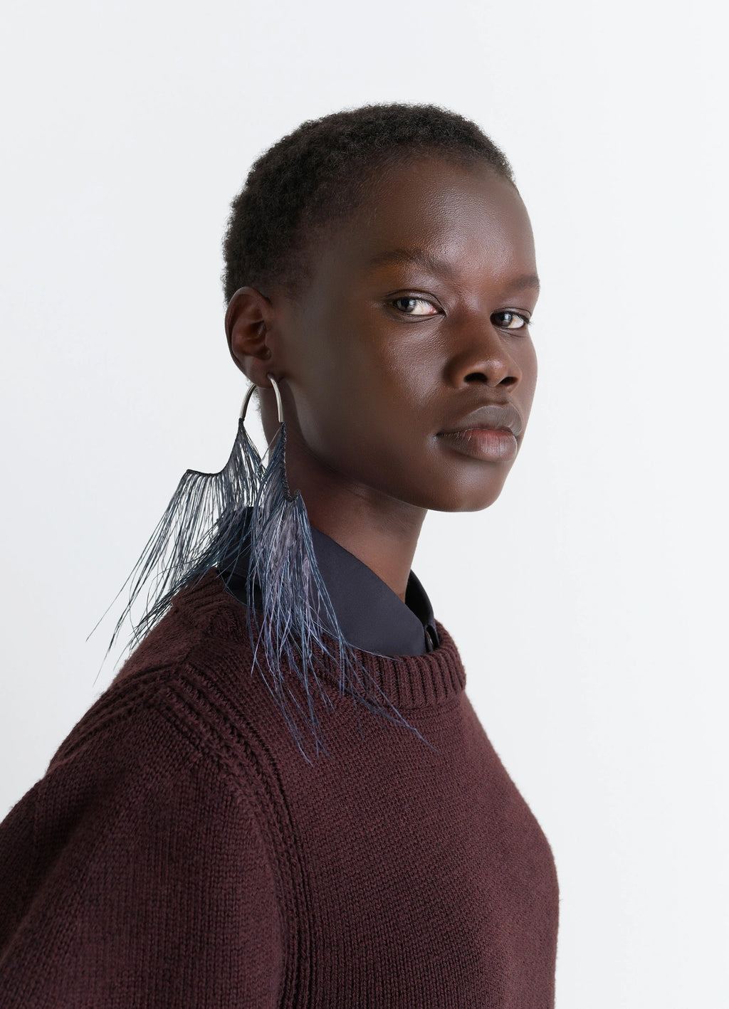 Feather earrings in dyed ostrich feathers, model shot, side view worn with sweater