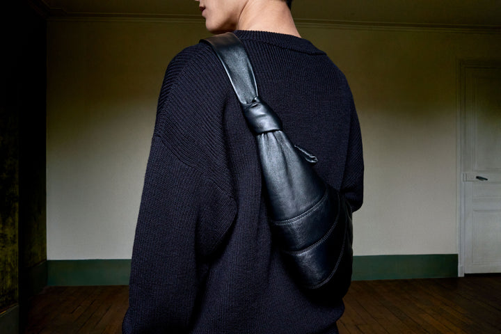 Leather shoulder bag in black leather, model shot, back view minimal design