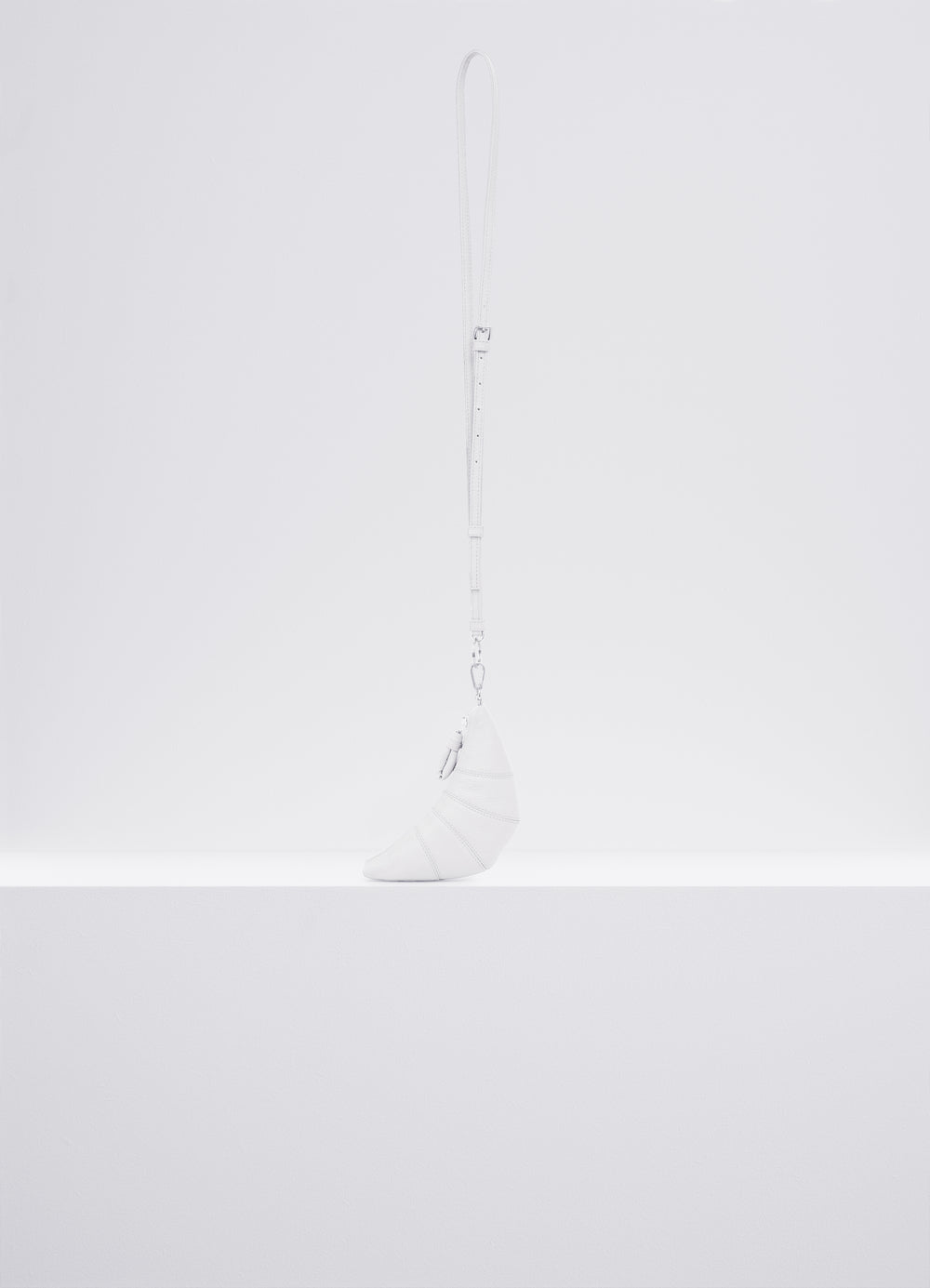 CROSS-BODY CROISSANT COIN PURSE in Soft grained leather, product shot, Side view Topstitched cutouts