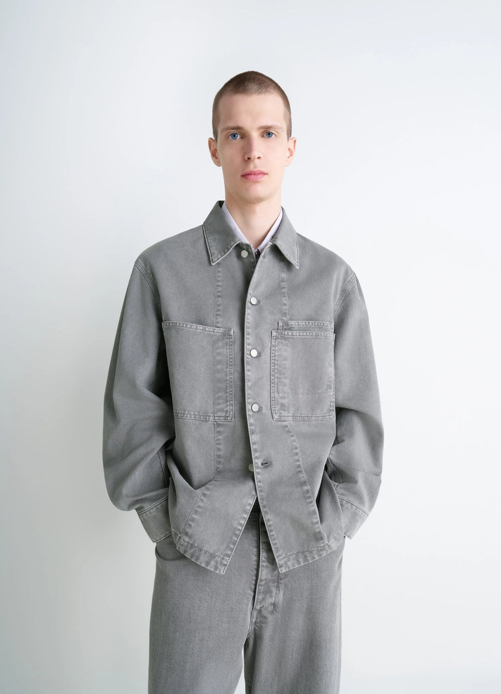 Lemaire Workwear Overshirt in Garment Dyed Snow Medium Denim, model shot, front view loose fit, dual chest pockets