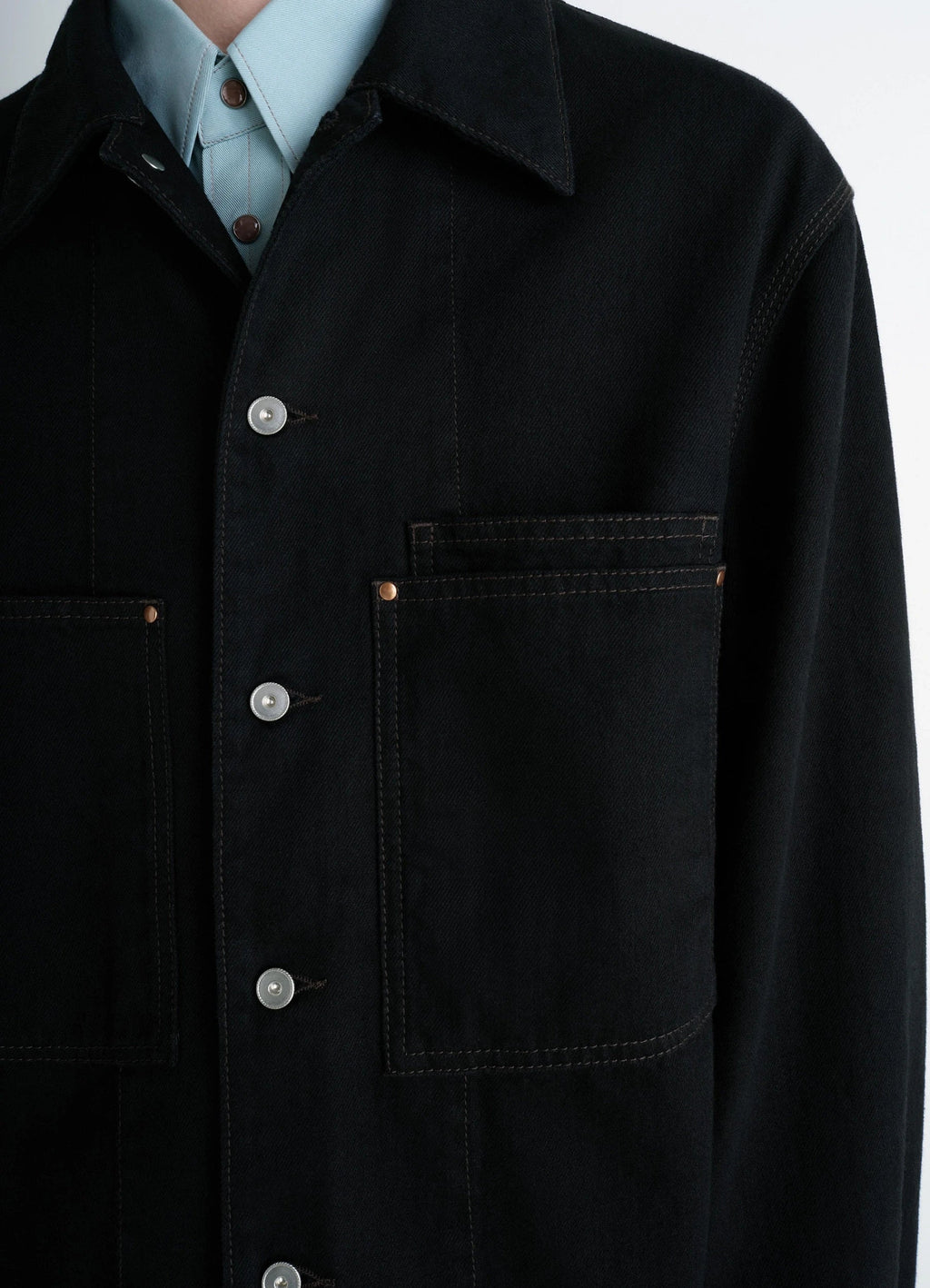 Lemaire workwear overshirt in deep black medium-weight denim, model shot, close-up view chest pockets, unbuttoned collar