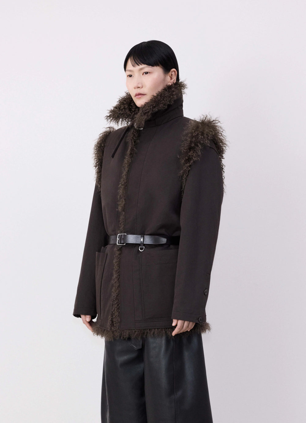 Lemaire Reversible Belted Long Shea in Dark Shearling and Cotton Twill, model shot, Side view Straight fit with belt