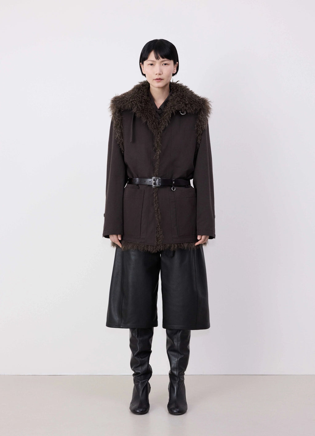Lemaire reversible belted long shea in dark shearling and cotton twill, model shot, full front view dark shearling accents