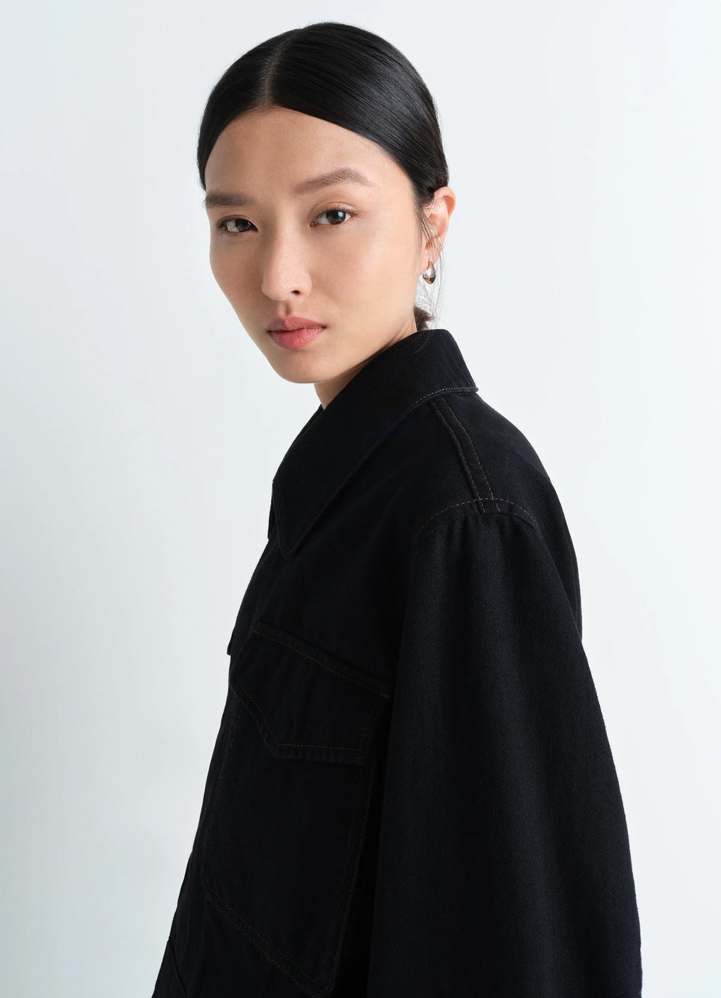 Lemaire two pocket cropped jacket in deep black heavy denim, model shot, profile view flat collar detail