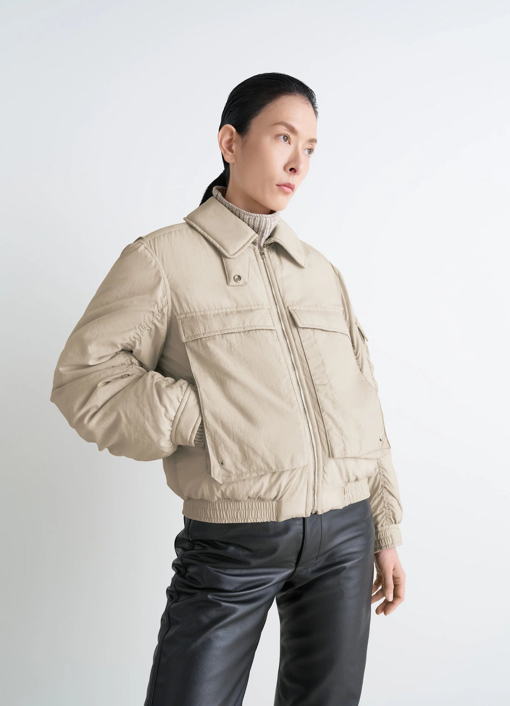 Lemaire Short Bomber in Beige Lightweight Nylon, model shot, Side view Removable collar, gusseted pockets