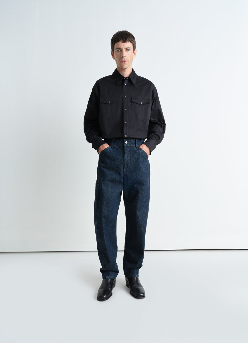 Twisted workwear pants in deep indigo heavy denim, model shot, front view twisted side seams