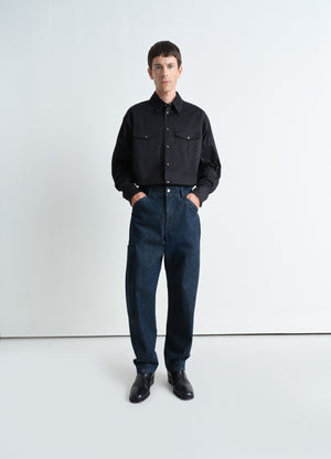 Twisted workwear pants in deep indigo heavy denim, model shot, front view twisted side seams