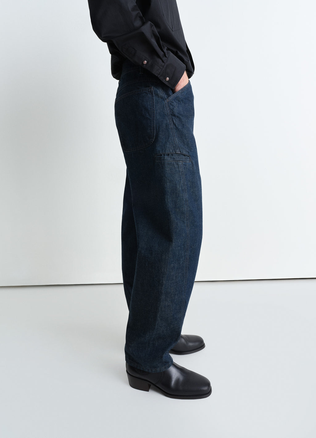Twisted workwear pants in deep indigo heavy denim, model shot, side view relaxed fit