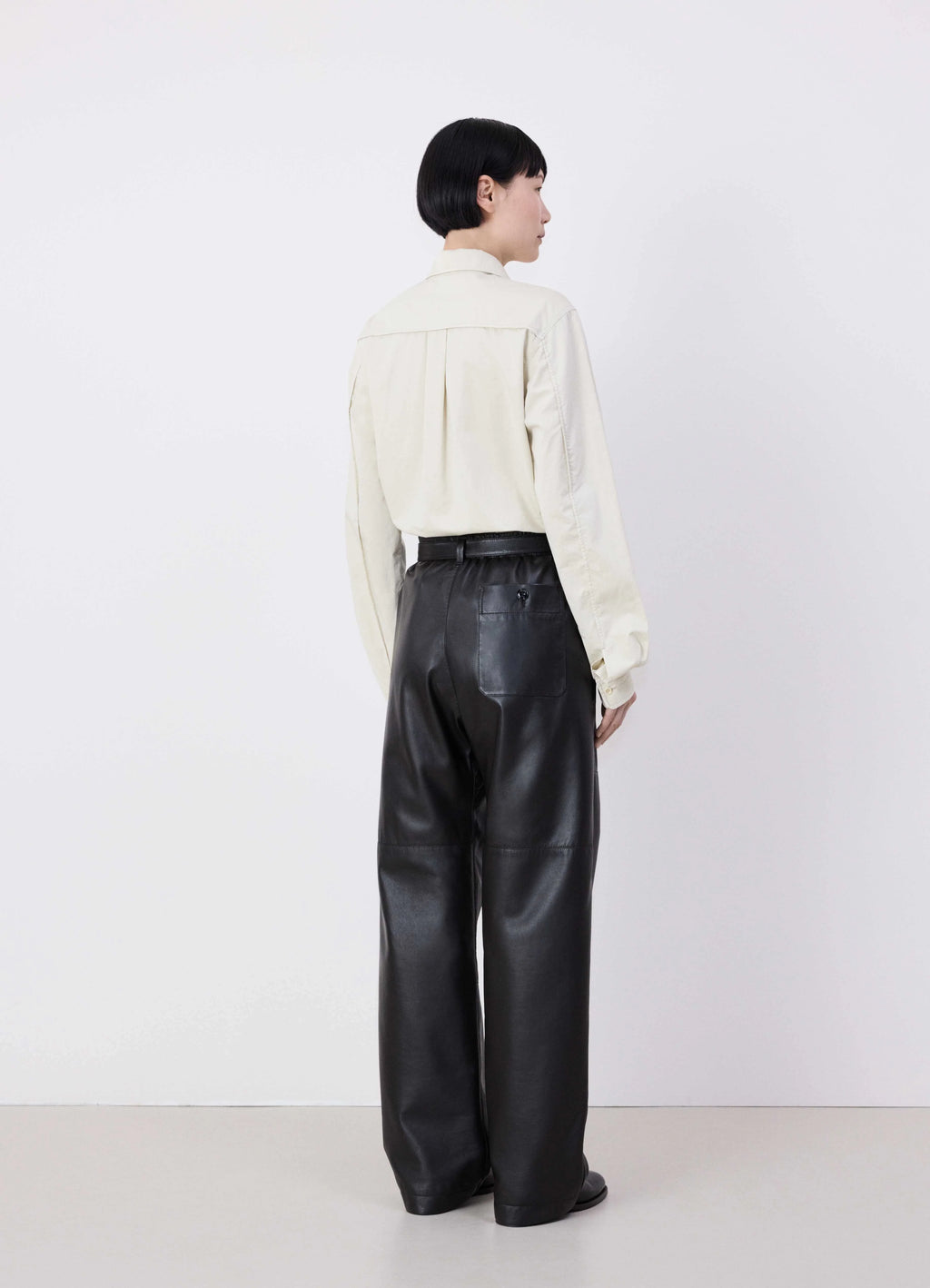 Lemaire drawstring parachute pants in black ultra-fine lamb leather, model shot, back view back pocket detail