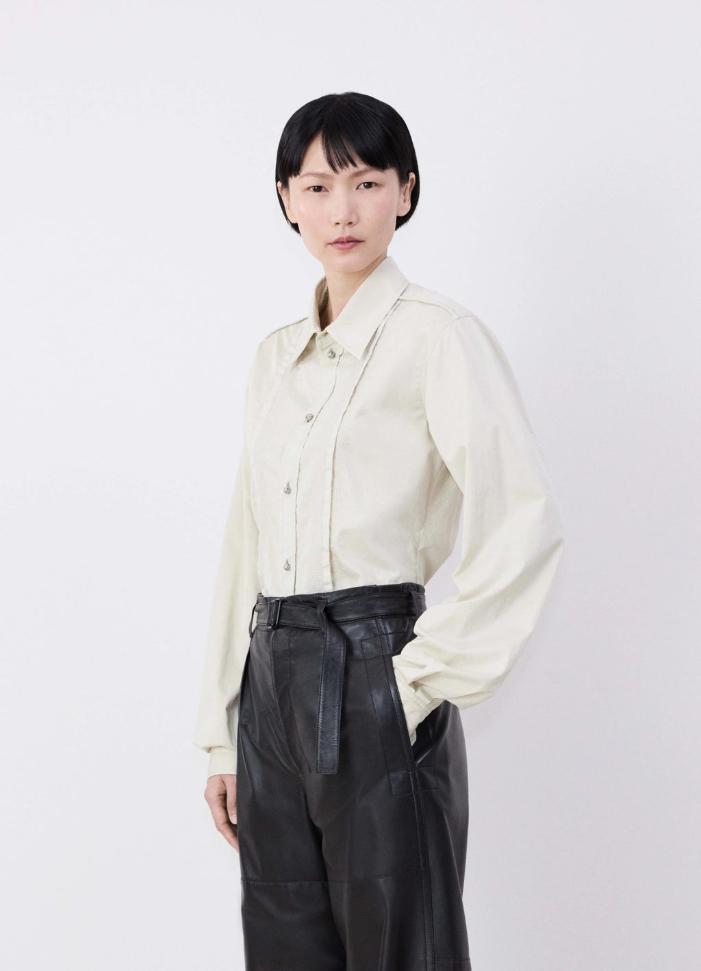 Lemaire drawstring parachute pants in black ultra-fine lamb leather, model shot, three-quarter view high waist detail