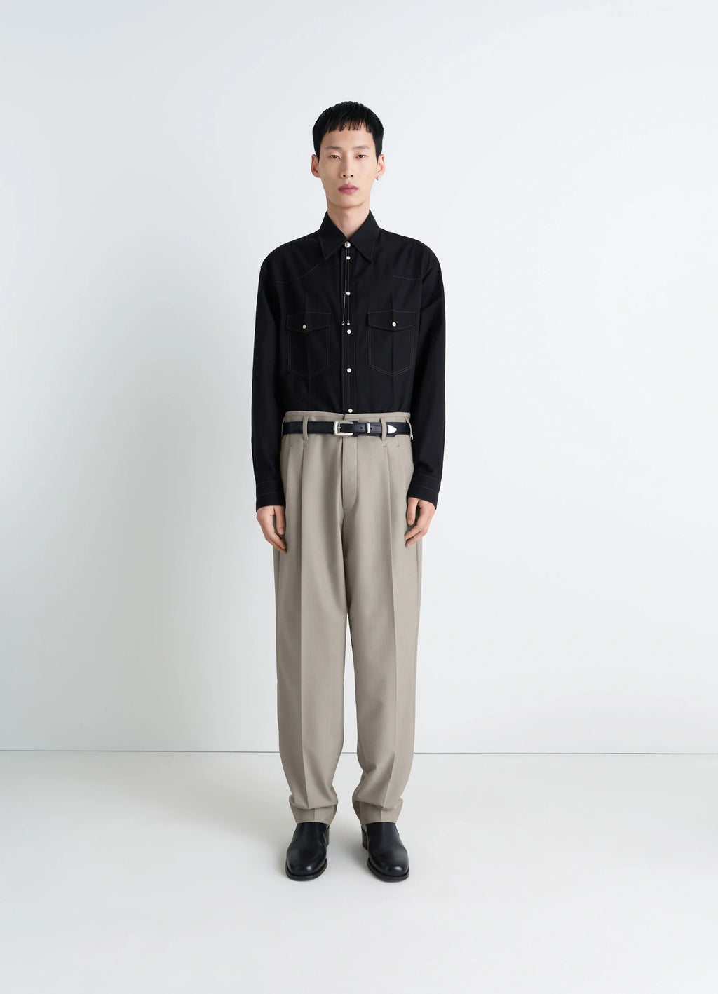 Lemaire pleated pants in tropical wool-blend suiting, model shot, front view metal buckle tabs