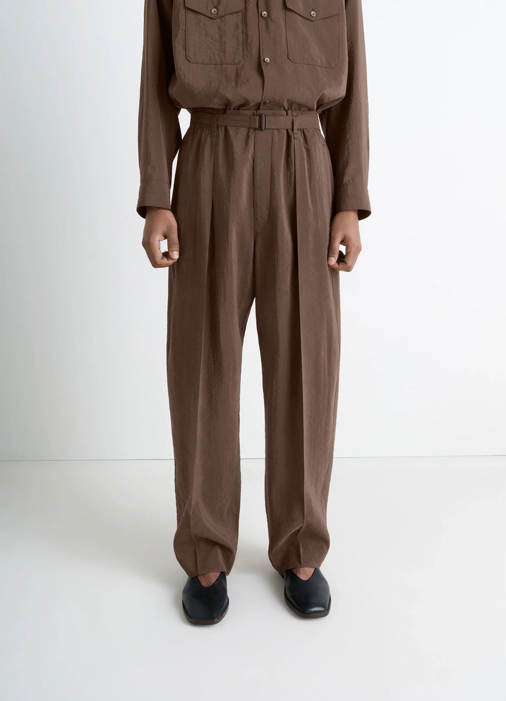 Lemaire belted relaxed pants in brown dry silk blend, model shot, back view tapered leg with pleats