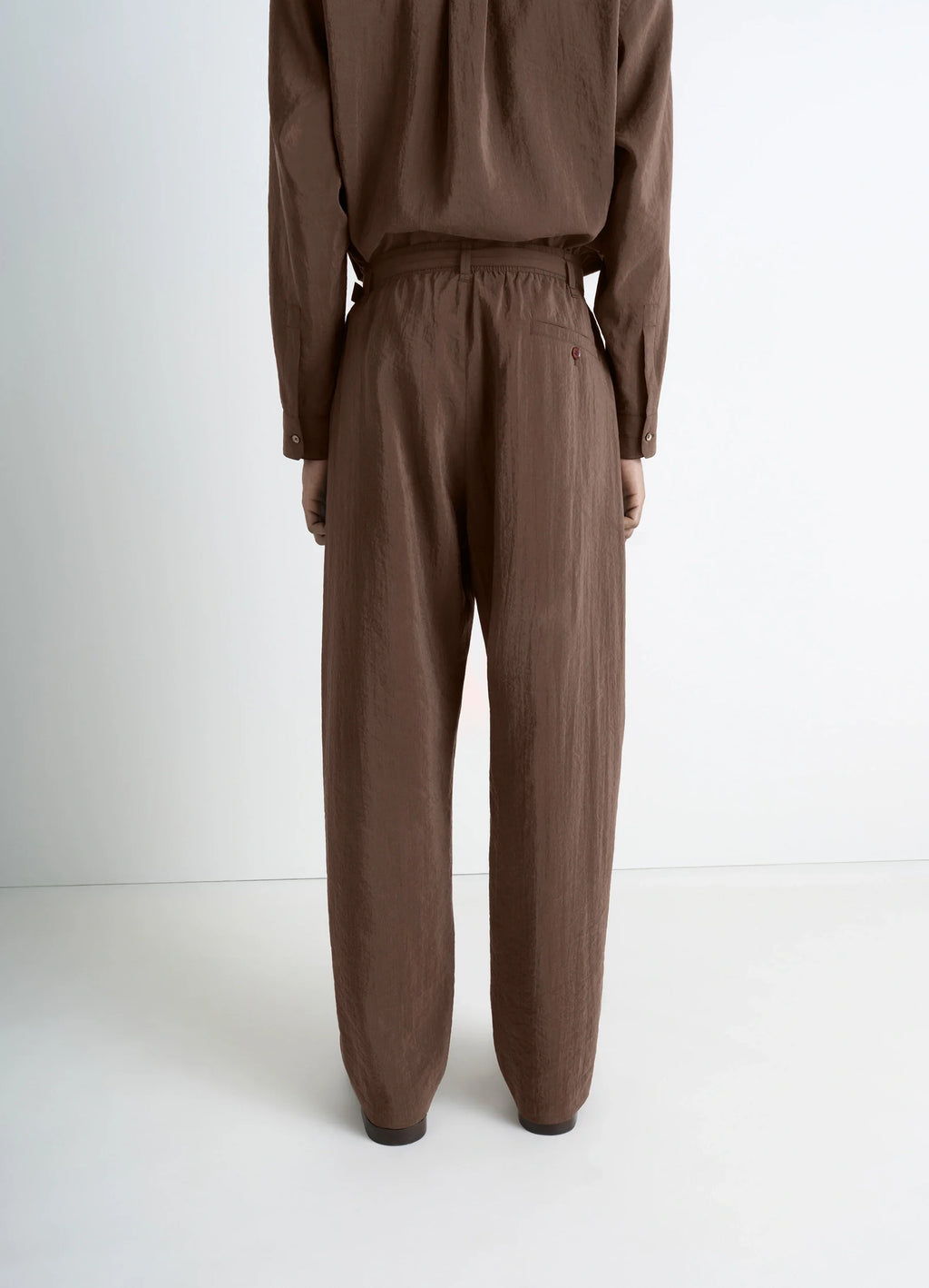 Lemaire belted relaxed pants in brown dry silk blend, model shot, rear view detail elastic waistband, relaxed fit