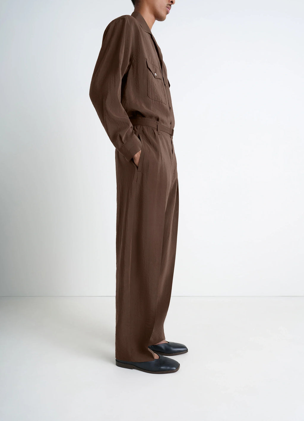 Lemaire belted relaxed pants in brown dry silk blend, model shot, profile view loose fit with pockets