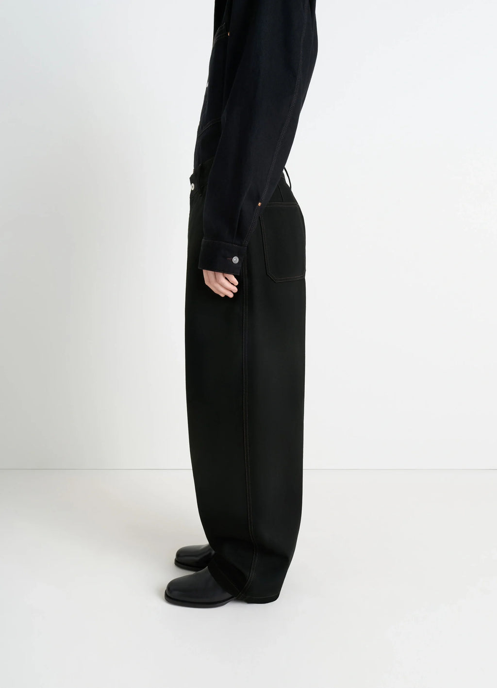 Lemaire maxi barrel workwear pants in deep black thick denim, model shot, side view barrel-cut wide leg