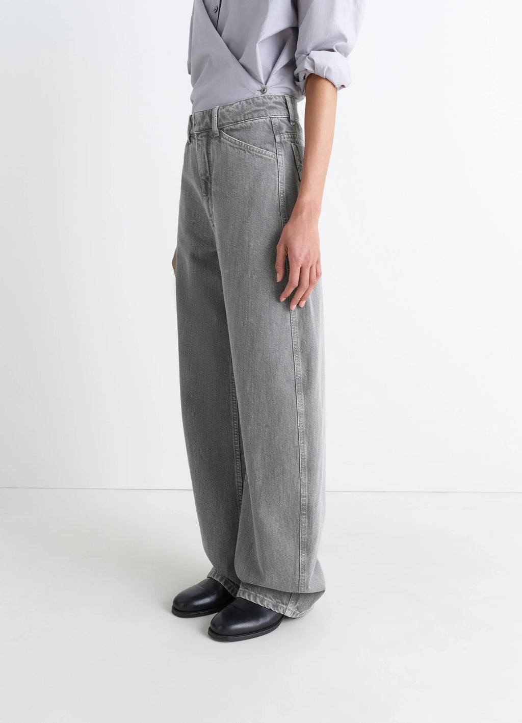 Lemaire high waisted curved pants in heather garment dyed snow denim, model shot, side view loose fit with draped leg