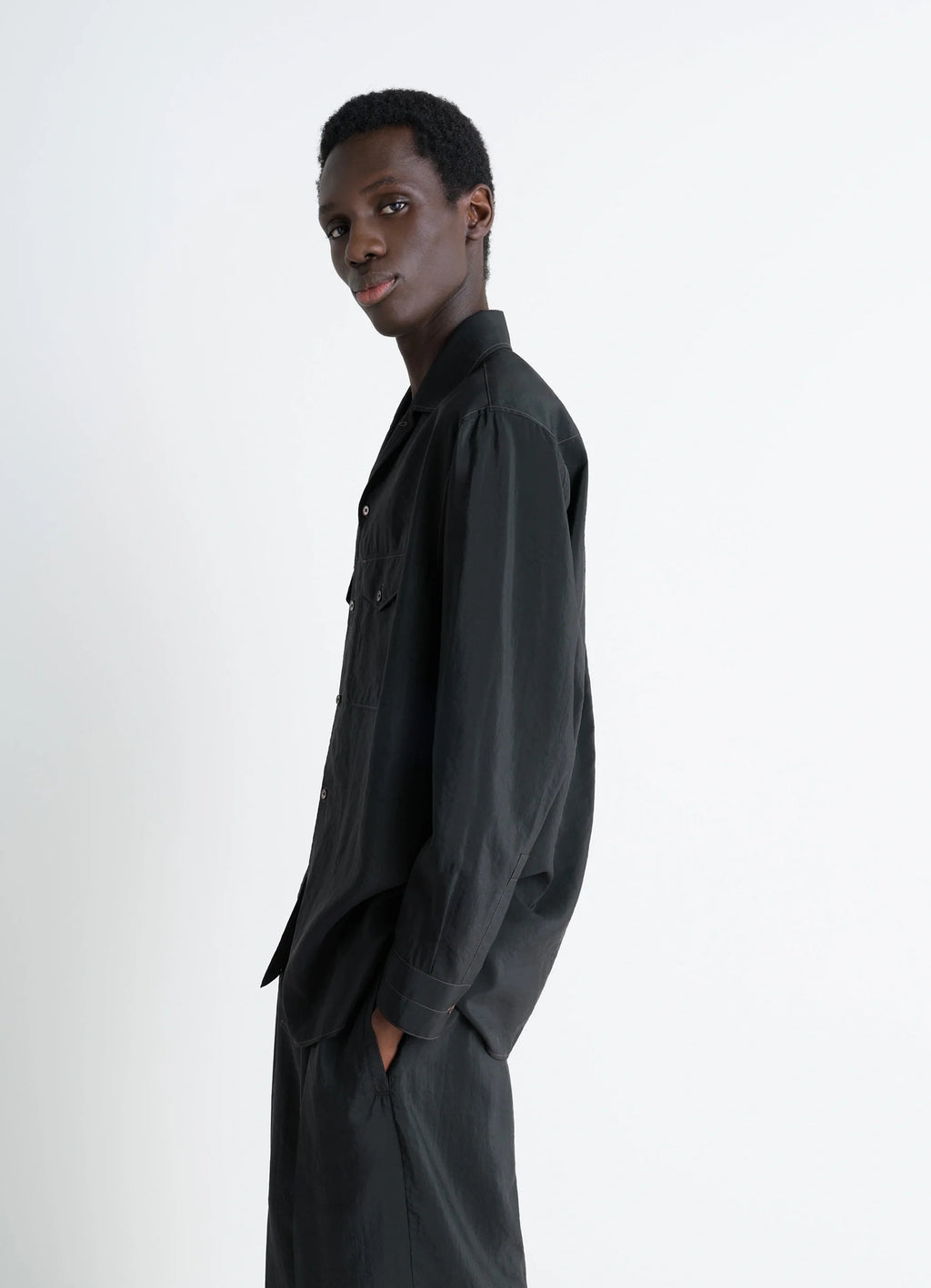 Lemaire convertible collar shirt in black dry silk blend, model shot, side view profile loose untucked sleeves