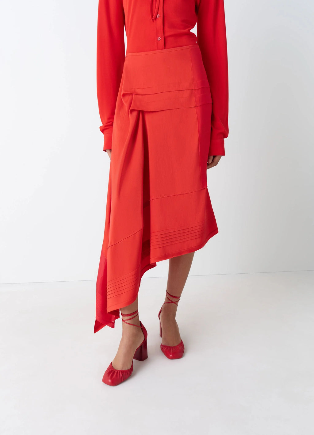 Skirt with pleats in patchwork of crêpe de chine, model shot, side view draped hemline