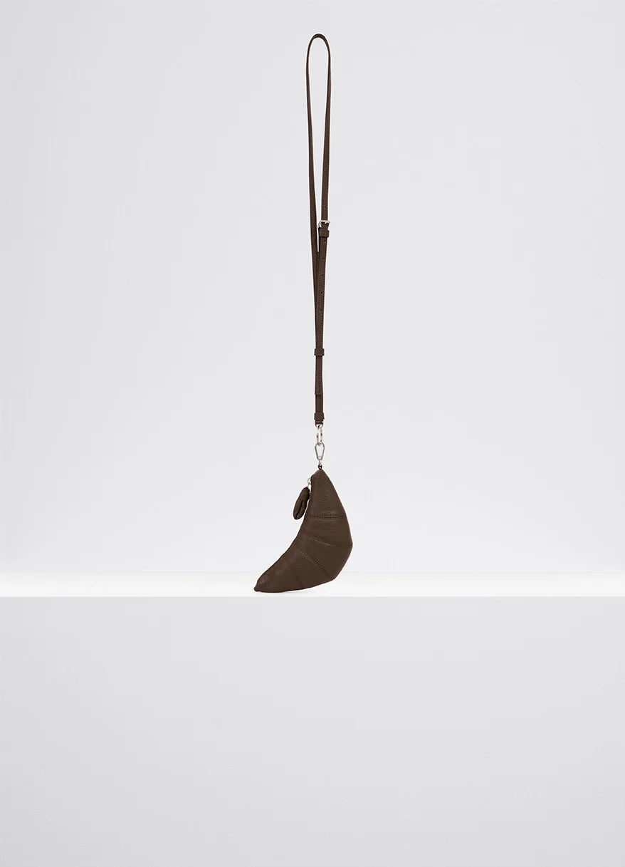 Cross-body croissant coin purse in soft grained leather, product shot, side view long removable strap
