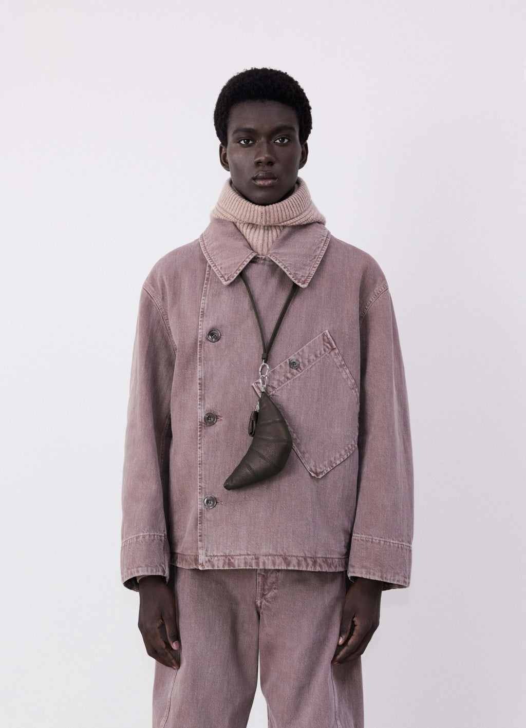 Cross-body croissant coin purse in soft grained leather, model shot, front worn hanging on neck