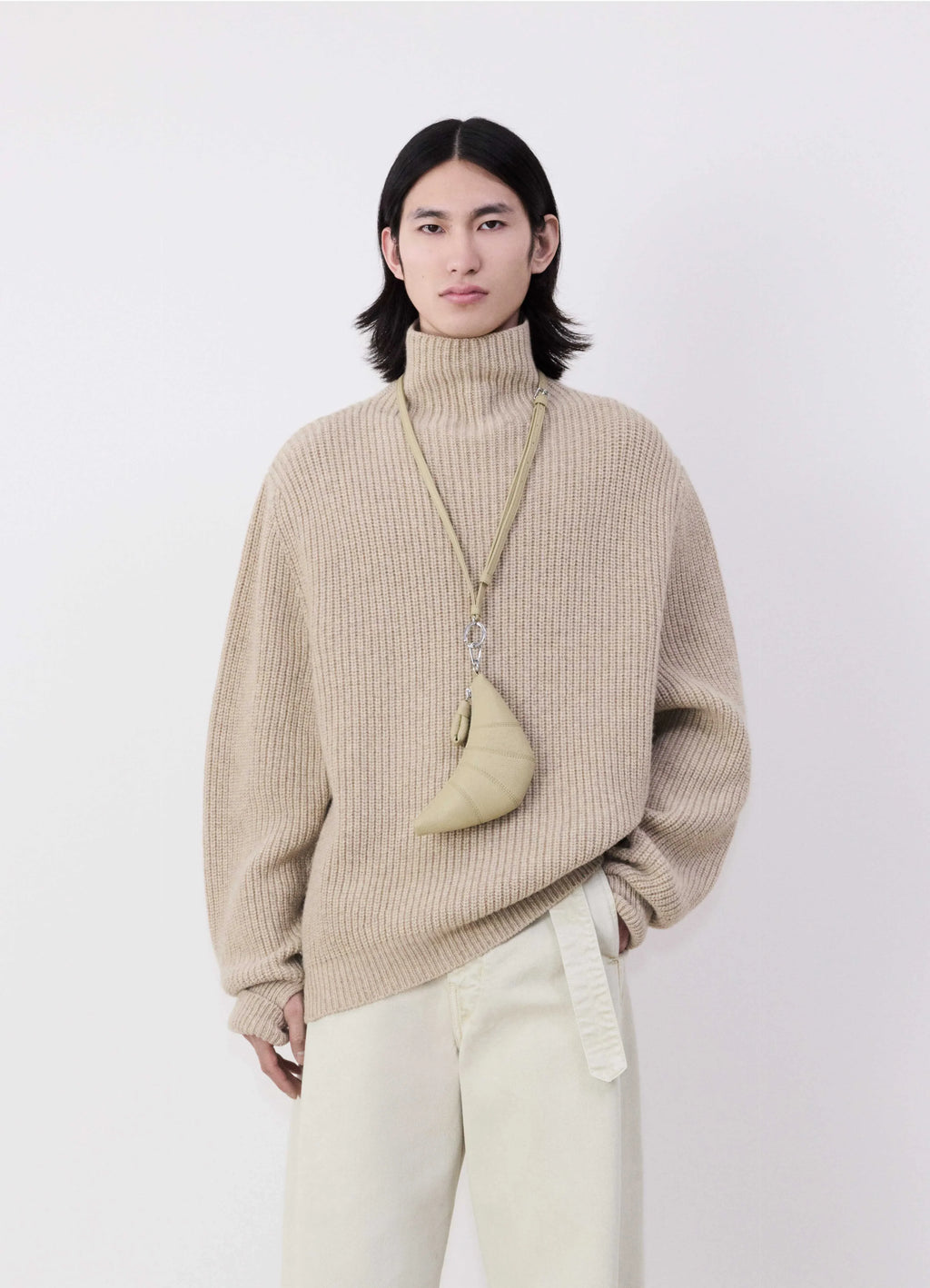 Cross-body croissant coin purse in soft grained leather, model shot, front worn view hanging crossbody style