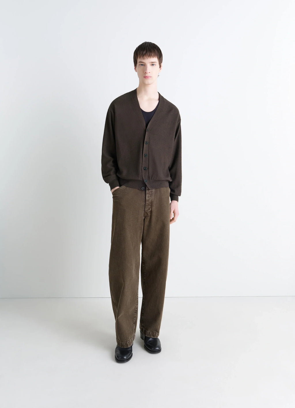 Lemaire relaxed twisted cardigan in knitted merino wool, model shot, full body porte straight sleeves, classic fit