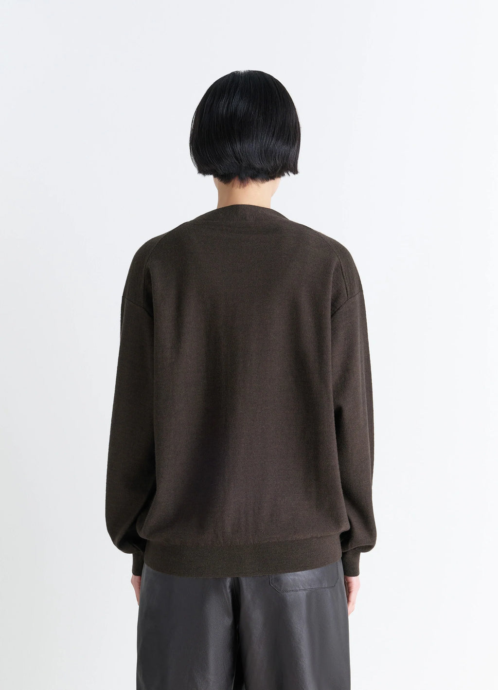 Lemaire relaxed twisted cardigan in knitted merino wool, model shot, back view ribbed hem