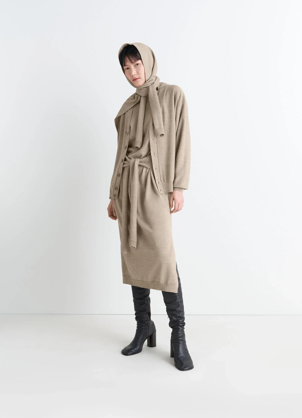 Lemaire relaxed twisted cardigan in light beige blended merino wool, model shot, side view belted waist accent