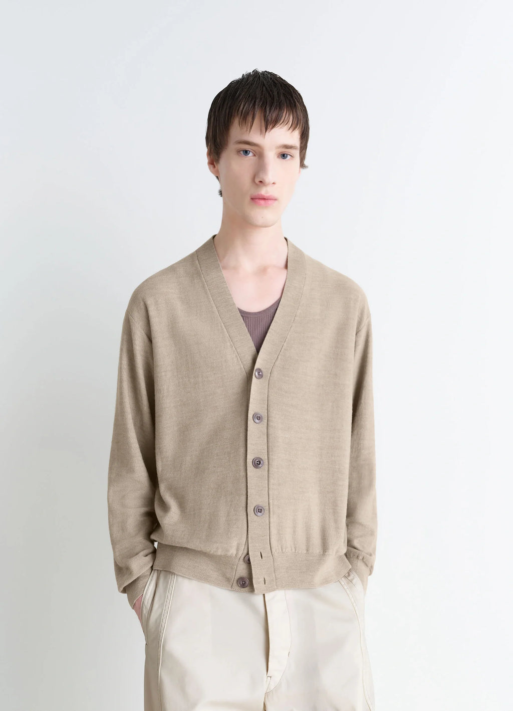 Lemaire relaxed twisted cardigan in light beige blended merino wool, model shot, upper body close-up v-neck, relaxed fit